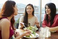 Three Female Friends Enjoying Lunch At Rooftop Restaurant