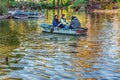 Three female friends ride a wooden boat with oars on the lake in Ciutadella Park