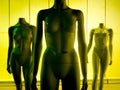 Three female mannequins in yellow-green tint