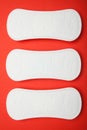 Three female pads on a red background, vertically