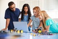 Three Female Students With Teacher Building Robot Vehicle In After School Computer Coding Class Royalty Free Stock Photo