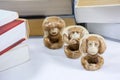 Three figurines of monkey with many thick books Royalty Free Stock Photo