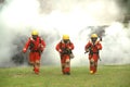 Three firefighters were walking out of the smoke from the fire. Straight ahead. Royalty Free Stock Photo