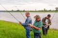 Three fishermen on the Bank of the lake preparing fishing tackle for fishing. Three fishermen on the lake