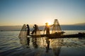 Three fishermen catches fish for food in sunrise in Inle lake