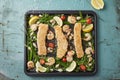 Three fishfingers and shrimps with vegetables on the baking tray Royalty Free Stock Photo