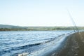 Three fishing poles at beach.