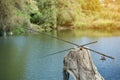 Three fishing rods on lake background.