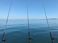 Three fishing rods lined up on the boat in the middle of calm sea Royalty Free Stock Photo