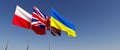 Three flags of countries of Europe on a flagpole on blue background. Flag of Ukraine, Poland and Great Britain. State symbols. Royalty Free Stock Photo