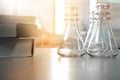 Three flask in science laboratory with book for education or stu