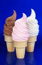 Three Flavors of Soft Serve Ice Cream on Blue Background Royalty Free Stock Photo