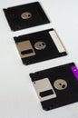 Three floppy disks on a white textured background Royalty Free Stock Photo