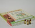 Three in focused bullets in front of two well known children`s books on a white background