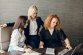 Three focused business women with different hairstyle work together in office. Royalty Free Stock Photo