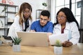 Three multiracial doctors having conference at hospital, working with laptop pc Royalty Free Stock Photo