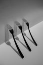 Three forks isolated with long shadows. Black and white. Creative still life art composition. Royalty Free Stock Photo