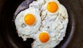 Three free range fried eggs in a hot non stick frying pan Royalty Free Stock Photo