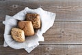 Three fresh buns with sunflower seeds, chia, oatmeal lie on a beige linen napkin. Wood background. Save the space. Fresh bakery Royalty Free Stock Photo