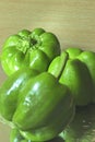 Three fresh capsicum on a reflective base