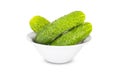 Three fresh green cucumbers in white bowl isolated on white background Royalty Free Stock Photo
