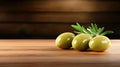 Three fresh green olives on wooden table with olive leaves Royalty Free Stock Photo