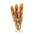 Three fresh home baked baguettes in glass jug on white.