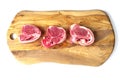 Three fresh lamb loin chops on a wooden board. Meat industry product, butcher craft and skill example Royalty Free Stock Photo