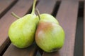 Three fresh organic green pears on a wooden rustic table.