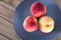 Three fresh peaches on the plate Royalty Free Stock Photo