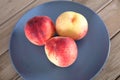 Three fresh peaches on the plate Royalty Free Stock Photo