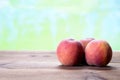 Three fresh peaches on a wooden table Royalty Free Stock Photo