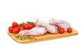 Three fresh raw chicken drumsticks on a wooden chopping Board with vegetables and herbs, on a white background Royalty Free Stock Photo