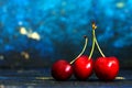 Three Fresh ripe cherries  close up pover green back Royalty Free Stock Photo