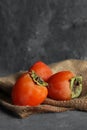 Three fresh ripe persimmon fruit on burlap Royalty Free Stock Photo
