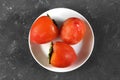 Three fresh ripe persimmon fruit on white plate Royalty Free Stock Photo
