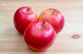 Three of fresh ripe red apple isolated on wooden table Royalty Free Stock Photo