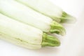 Three fresh vegetable marrow lies on white table. Closeup, diagonal view