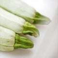 Three fresh vegetable marrow lies on windowsill. Closeup, diagonal view.