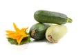 Three fresh zucchini with green leaves and flower isolated on a white background Royalty Free Stock Photo