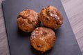 Three freshly baked fruit scones on slate plate . Royalty Free Stock Photo