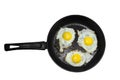 Three fried eggs in a cast iron frying pan isolated on white background. Concept of fast and healthy breakfast, top view Royalty Free Stock Photo