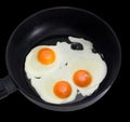 Three fried eggs on the frying pan during cooking closeup Royalty Free Stock Photo