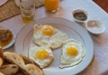 Three fried eggs on white plate for breakfast