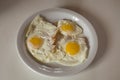 Three fried eggs on a white plate