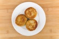 Three fried meatballs in white plate glass on wooden table Royalty Free Stock Photo