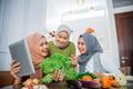 friend with hijab looking at tablet to make new food Royalty Free Stock Photo