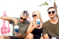 Three friends on the beach drinking cocktails fun Royalty Free Stock Photo