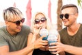 Three friends on the beach drinking cocktails fun Royalty Free Stock Photo