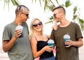 three friends cheerful company rest on a tropical beach and drink cocktails, very, magazine concept Royalty Free Stock Photo